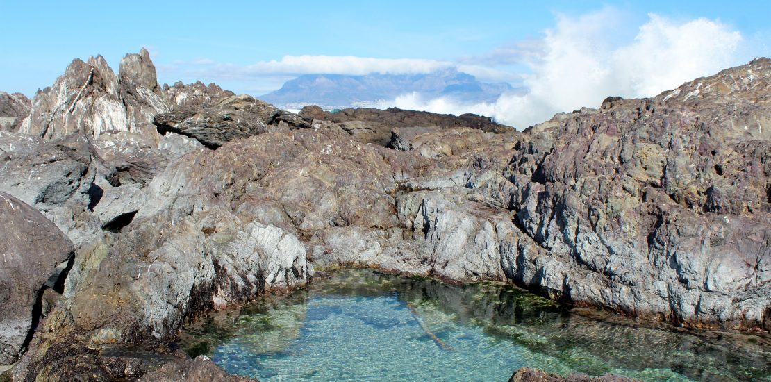 water in a pool high atop table in mountain in Cape Town, South Africa. The water is blue and crystal clear.