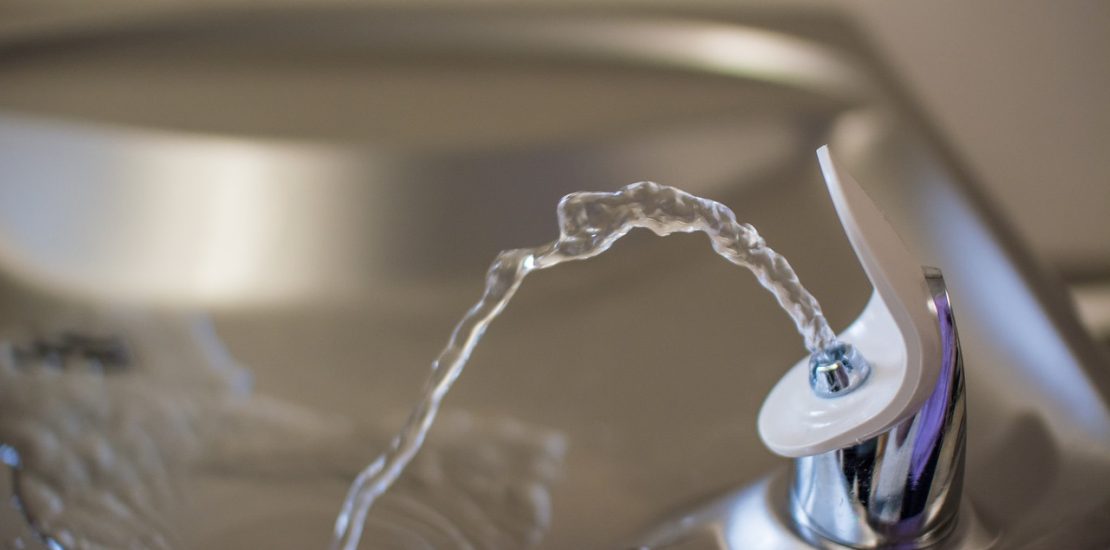 water is coming out of a drinking fountain - close up image