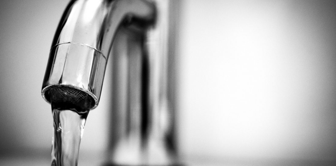 close up of water flowing out of a tap